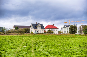 Fototapeta na wymiar Colourful homes of Iceland with green meadow in summer season