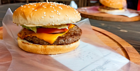 Burger with beef on a wooden table with gloves for food. burger order