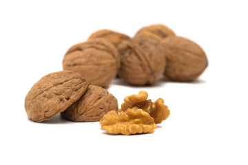 Delicious whole and broken walnuts, isolated on white background