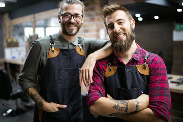 Portrait of young male barbers and hairdressers in barber shop