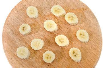 sliced banana slices on a wooden board isolated on a white background. View from above.