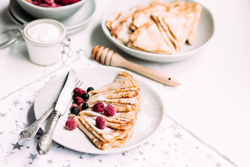 Pancakes with wild berries in a plate.Maslenitsa