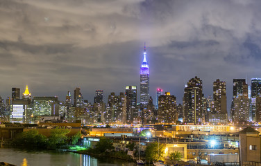 Night view of Midtown Manhattan panoramic skyline with East River, New York City