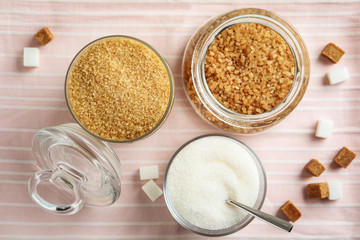 Various bowls with different sorts of sugar on table, flat lay