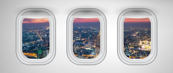 Airplane windows with Bangkok night skyline view, Thailand. Travel and holiday abstract concept