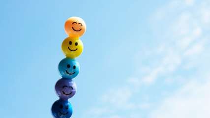 Cartoon emoji colorful smiley face on blue sky background