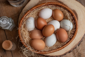 A lot of eggs put in the basket and place on the wooden table.
