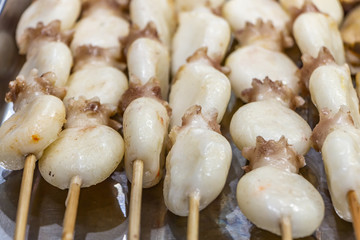 Traditional Chinese sea food octopus on wooden skewers on a big large metal pan