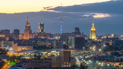 Obraz premium Ostankino tv tower and stalin skyscrapers near railway station day to night timelapse. Residential buildings and roofs at summer in Moscow, Russia