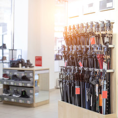 Sale of men's and women's genuine leather belts in a store. Selling quality shoes, copy space