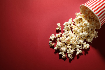 Delicious popcorn on red background, top view. Space for text