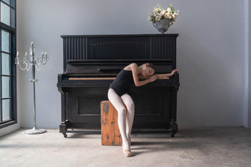 Cute little girl ballet dancer falls asleep at old piano, while practicing in studio © chomplearn_2001