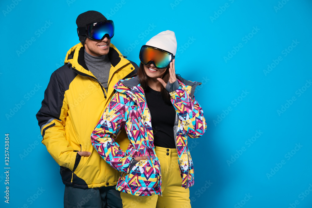 Poster Couple wearing stylish winter sport clothes on light blue background