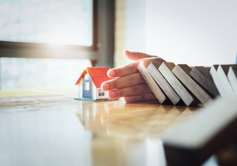 Business risk control Real estate concept,  Businessman protect wooden block fall to planning and...