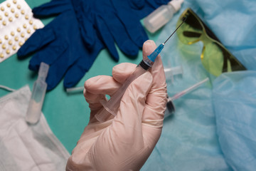 Doctor's hand holds a syringe. Hand with a syringe on a background of medical instruments.