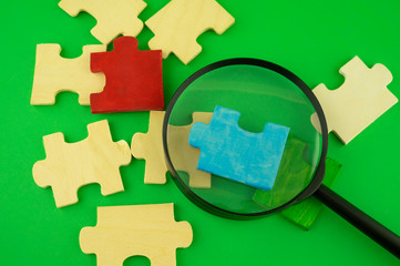 Jigsaw puzzle pieces with magnifying glass