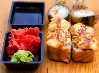 Delicious sushi rolls on wooden background