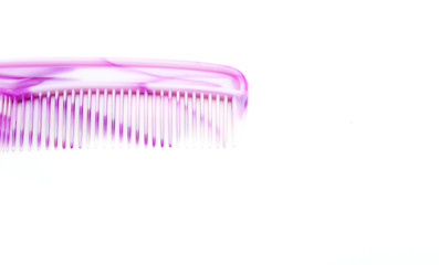 White and pink plastic hair comb with small and large teeth on a white isolated background. Comb for the head. Abstraction