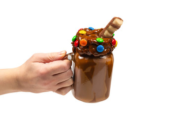 Chocolate milkshake with whipped cream, cookies, waffles, served in glass mason jar. 