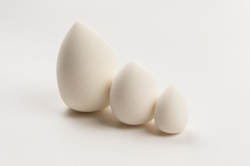 Small, medium and large  white beauty blender isolated.