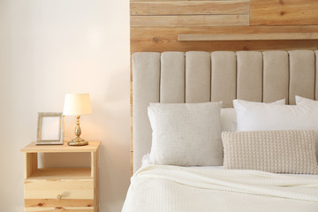 Comfortable bed with pillows in modern room interior