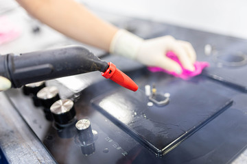 cleaning glass-ceramic gas stove with a steam cleaner.