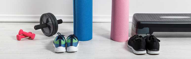 panoramic shot of yoga mats, sneakers, step platform and sport equipment on floor at home - obrazy, fototapety, plakaty