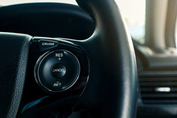 Obraz premium cruise control or speed control system on steering wheel in modern car, shallow depth of field
