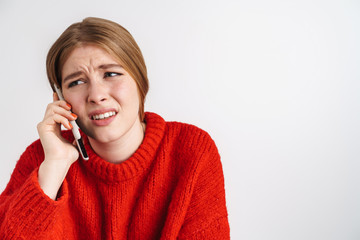 Photo of confused beautiful woman in red sweater talking on smartphone