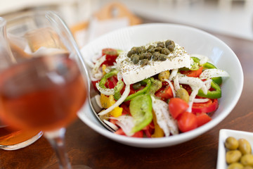 Traditional greek salad and carafe of wine in a tavern on the island in Greece.