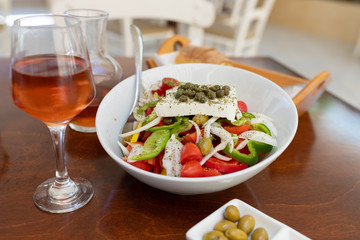 Traditional greek salad and carafe of wine in a tavern on the island in Greece.