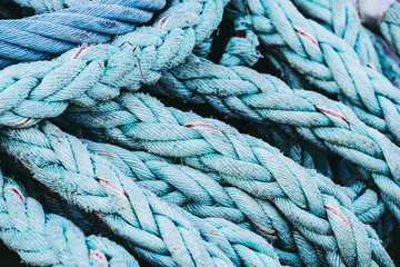 Close up sur une grosse corde tressée sur le quai d'un port, matériel de pêche