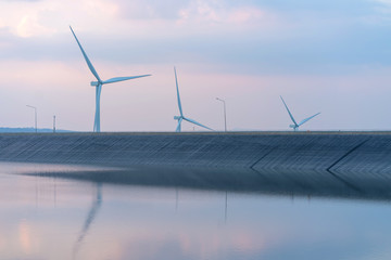 wind turbine generating electricity on dam catchment landscape energy transmission distribution...