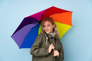 Woman holding an umbrella isolated on blue background