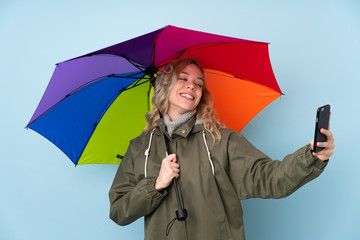 Woman holding an umbrella isolated on blue background