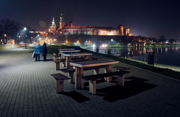 Chess tables at the background of Wawel Castle at night.