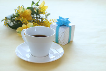 プレゼントとコーヒーとミモザの花