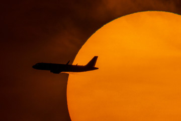 Silhouette of passenger airplane with the morning sunrise background