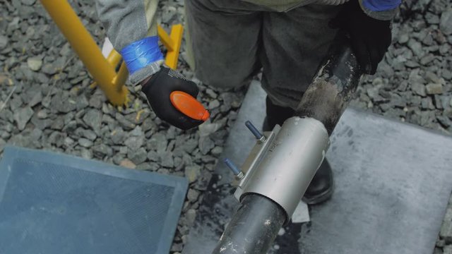 Pipe leak check tightness gas leak water foam clamp installation man repairs a pipeline emergency service rescuer overalls in pit