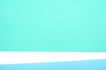 Abstract geometric background of white, green and blue pastel cardboard. Copy space for your text.