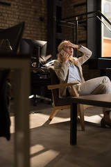 selective focus of tired business woman talking on smartphone while suffering from headache