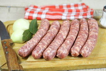 saucisse de Toulouse crues sur une planche à découper