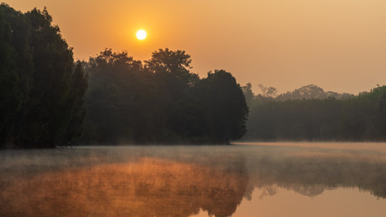 Scenic View Of Lake Against Sky During Sunrise. Reflection of the sun on the water surface.