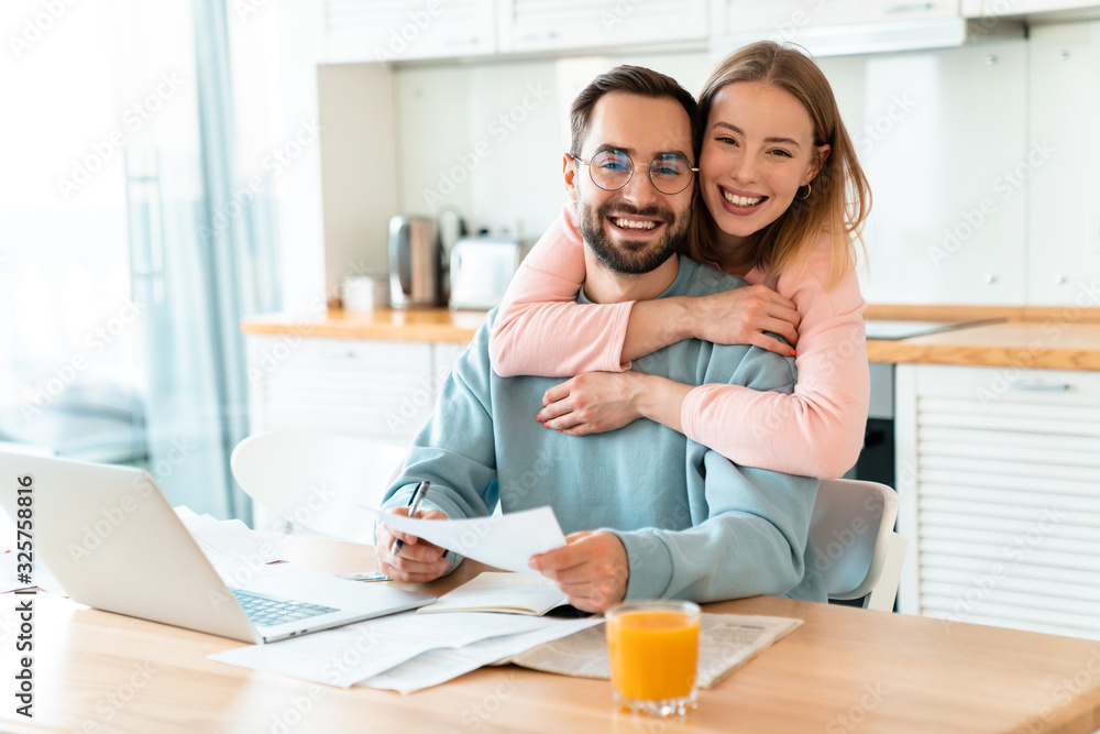 Sticker portrait of smiling couple hugging while working with documents