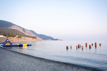Deserted, evening beach by the sea on a background of old mountains.