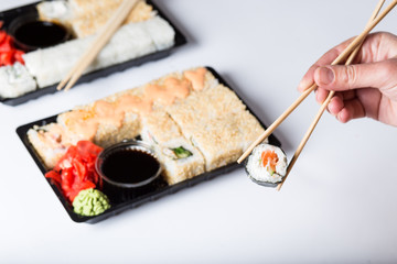 Picking one roll of sushi with sticks