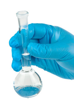 Hand holds a test tube with water on a white background.