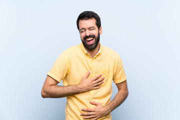 Fototapeta premium Young man with beard over isolated blue background smiling a lot