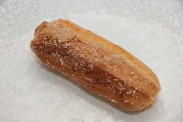 fresh eclair on a transparent plate on a white background
