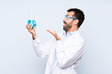 Young scientific holding laboratory flask over isolated background